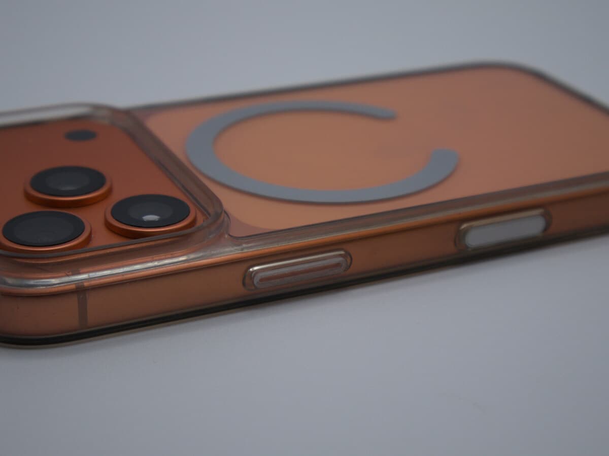 Nick's iPhone in an orange MagSafe case, photographed close on the bench