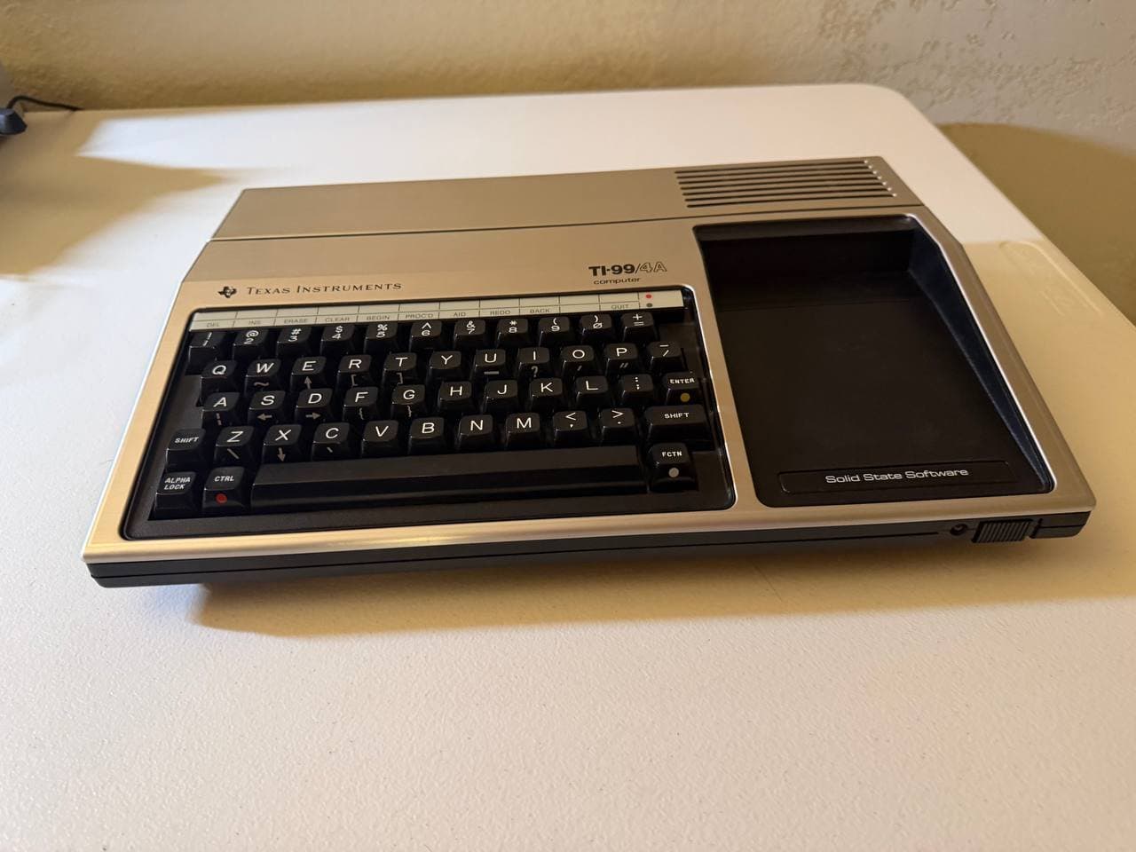 TI-99/4A console — full three-quarter view, silver chassis, all keys present, no yellowing