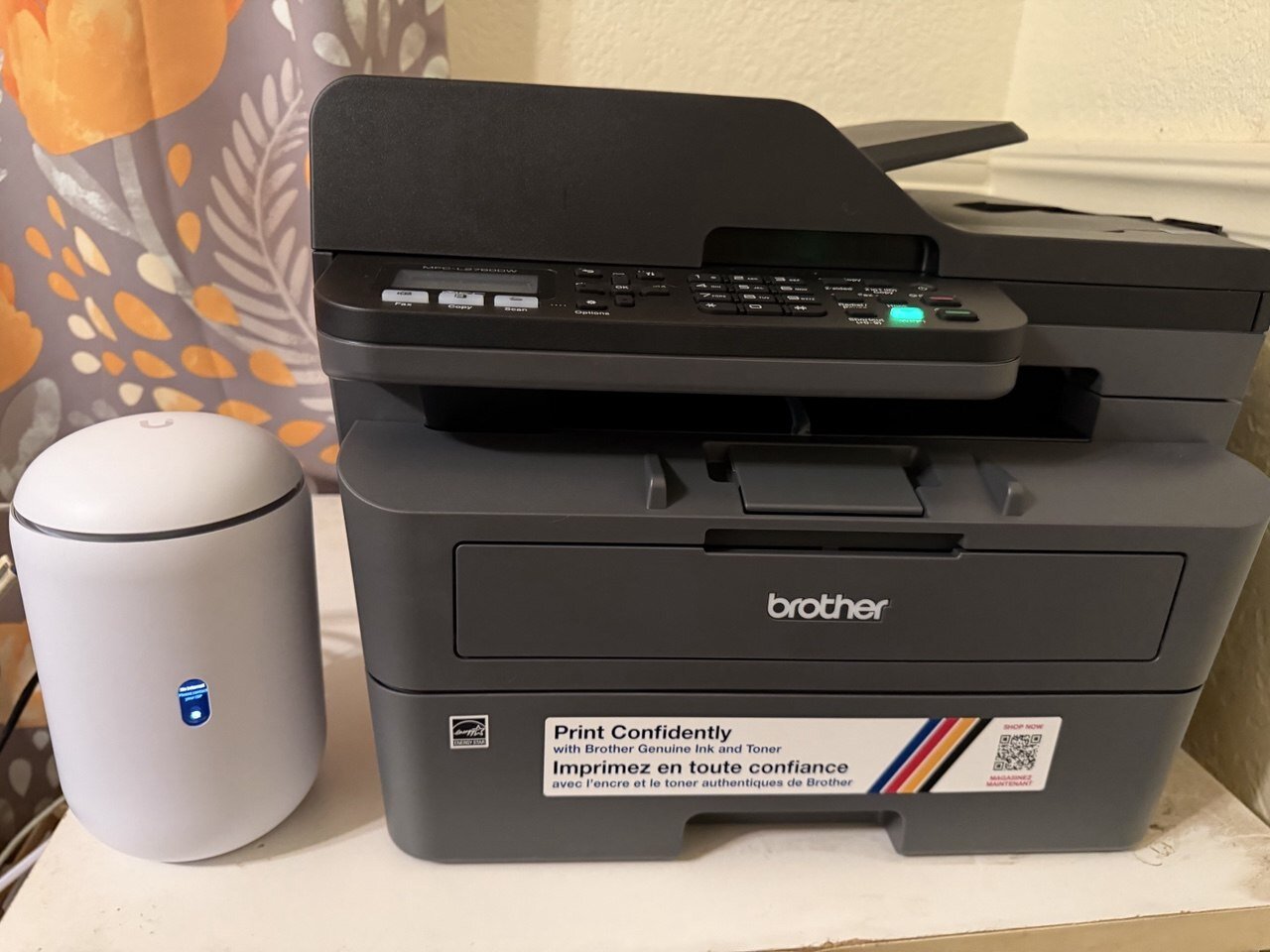 Nick's home desk with a Brother laser printer and UniFi network gear